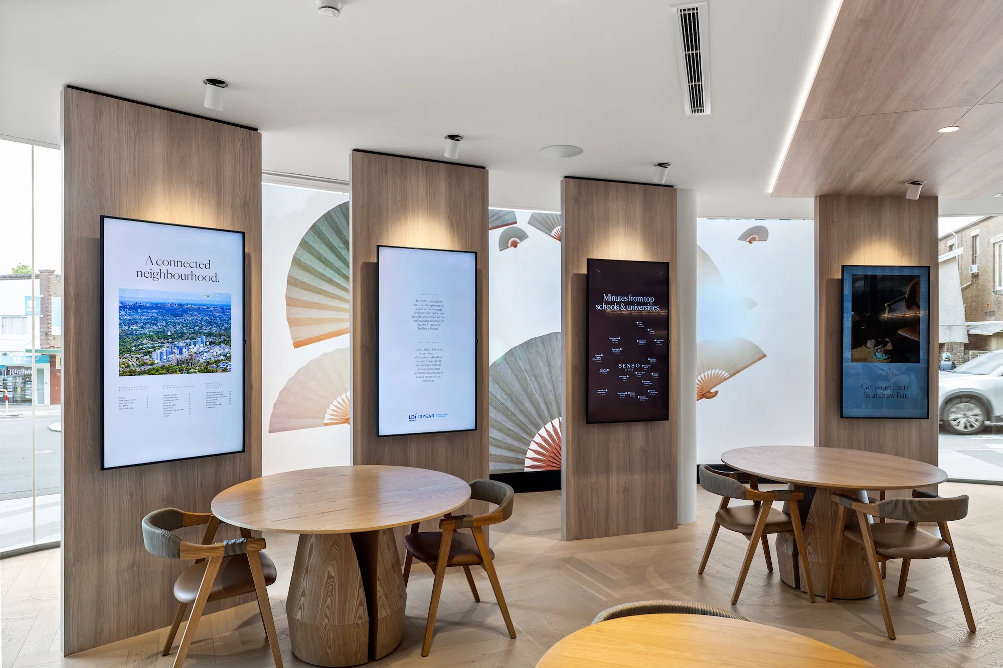 Digital signage screens displaying property marketing content in a display suite